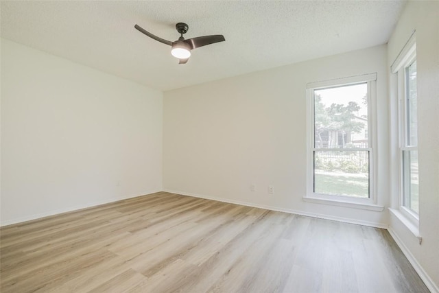 8600 Fathom Cir Unit 1303, Austin, TX 78750 - empty room featuring light wood-style floors, plenty of natural light, ceiling fan, a textured ceiling, and baseboards