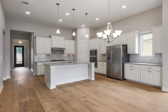 3324 Venezia Vw, Leander, TX 78641 - kitchen with stainless steel appliances, decorative backsplash, under cabinet range hood, a chandelier, and white cabinetry