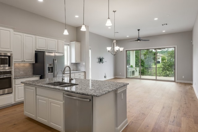 3324 Venezia Vw, Leander, TX 78641 - kitchen with stainless steel appliances, a sink, a ceiling fan, open floor plan, and decorative backsplash