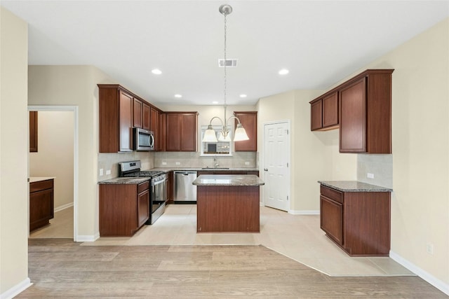 4203 Birdwatch Loop Unit 14, Pflugerville, TX 78660 - kitchen with stainless steel appliances, backsplash, a kitchen island, pendant lighting, and dark stone counters