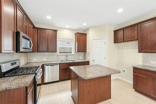 4203 Birdwatch Loop Unit 14, Pflugerville, TX 78660 - kitchen with stainless steel appliances, decorative backsplash, a kitchen island, light stone countertops, and recessed lighting