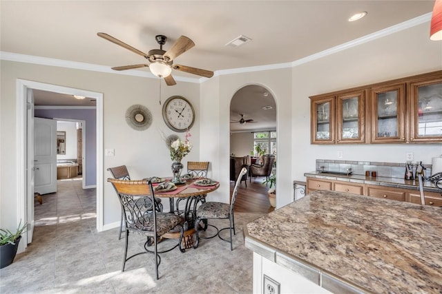 7500 Muleshoe Bend Trl, Marble Falls, TX 78654 - dining room with a ceiling fan, ornamental molding, arched walkways, baseboards, and light tile patterned floors