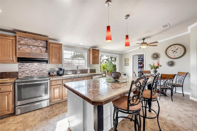 7500 Muleshoe Bend Trl, Marble Falls, TX 78654 - kitchen with stainless steel appliances, crown molding, extractor fan, a sink, and a breakfast bar