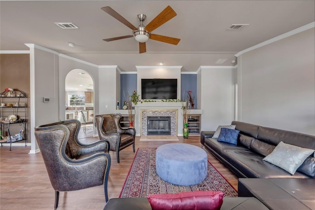 7500 Muleshoe Bend Trl, Marble Falls, TX 78654 - living room with wood finished floors, ceiling fan, ornamental molding, a fireplace, and arched walkways