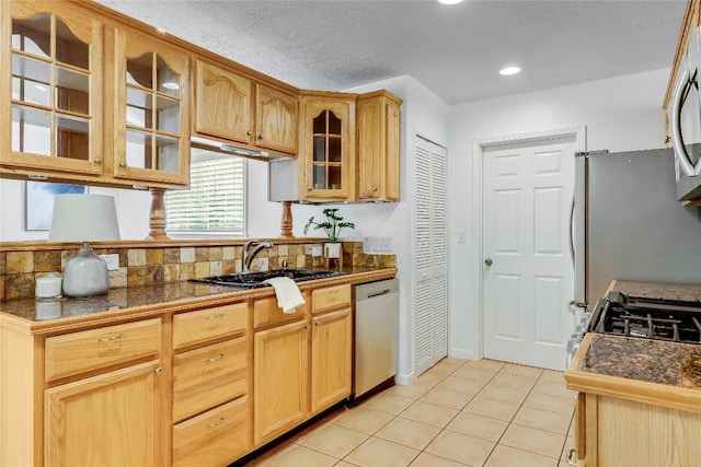 1505 Wheless Ln, Austin, TX 78723 - kitchen with appliances with stainless steel finishes, glass insert cabinets, tile counters, recessed lighting, and a textured ceiling