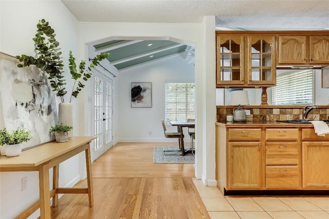1505 Wheless Ln, Austin, TX 78723 - kitchen featuring plenty of natural light, light wood-type flooring, glass insert cabinets, vaulted ceiling, and french doors
