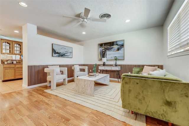 1505 Wheless Ln, Austin, TX 78723 - living room featuring a wainscoted wall, ceiling fan, recessed lighting, light wood-type flooring, and a textured ceiling