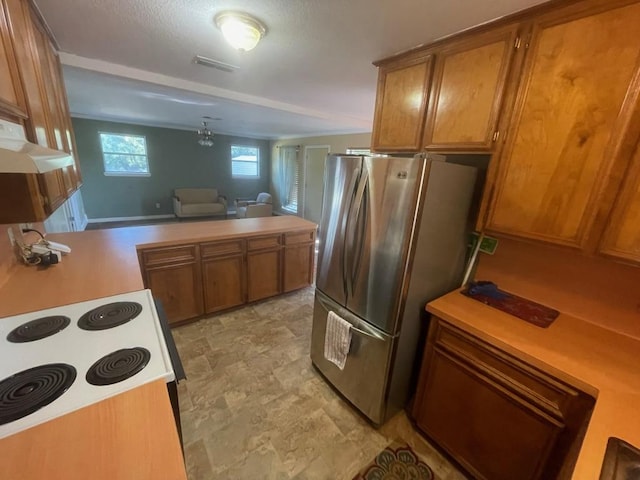 309 Stolle Ln, Flatonia, TX 78941 - kitchen featuring freestanding refrigerator, brown cabinets, light countertops, and a peninsula