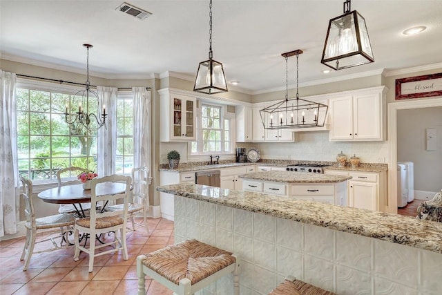 303 Rio Bravo Rd, Georgetown, TX 78628 - kitchen with a chandelier, a kitchen island, white cabinetry, tasteful backsplash, and light tile patterned floors
