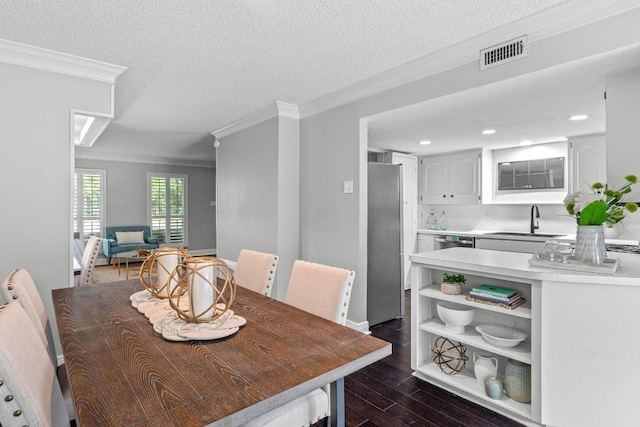 6109 Bullard Dr Unit A, Austin, TX 78757 - dining space featuring dark wood-style flooring, ornamental molding, a textured ceiling, and recessed lighting