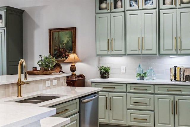 9122 Balcones Club Dr Unit 9, Austin, TX 78750 - kitchen featuring green cabinetry, a sink, tasteful backsplash, stainless steel dishwasher, and glass insert cabinets