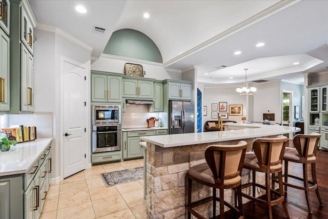 9122 Balcones Club Dr Unit 9, Austin, TX 78750 - kitchen with green cabinets, stainless steel appliances, a chandelier, tasteful backsplash, and light countertops