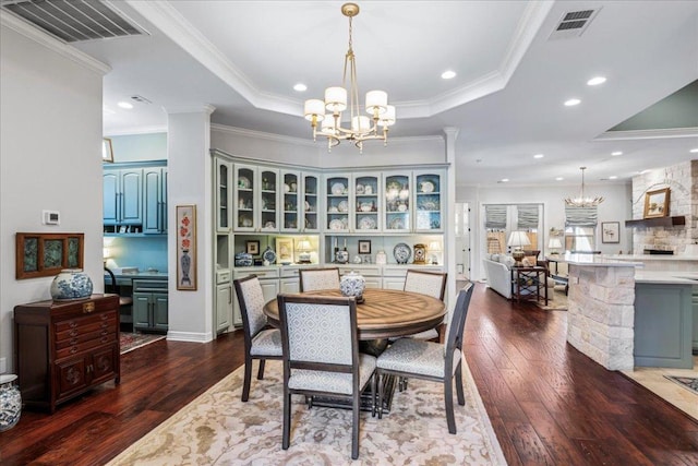 9122 Balcones Club Dr Unit 9, Austin, TX 78750 - dining space featuring a raised ceiling, a chandelier, dark wood-style flooring, ornamental molding, and recessed lighting