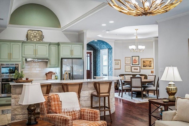 9122 Balcones Club Dr Unit 9, Austin, TX 78750 - kitchen featuring a chandelier, green cabinetry, appliances with stainless steel finishes, arched walkways, and dark wood-type flooring