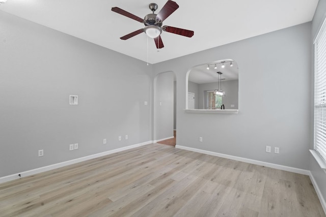 2009 Campfield Pkwy, Austin, TX 78745 - empty room featuring arched walkways, a ceiling fan, wood finished floors, and baseboards