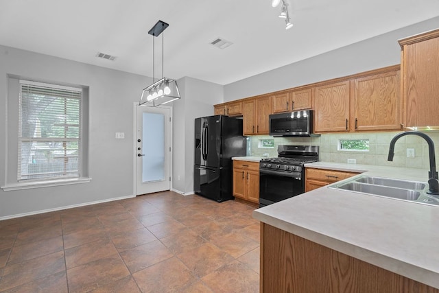 2009 Campfield Pkwy, Austin, TX 78745 - kitchen with appliances with stainless steel finishes, a sink, light countertops, backsplash, and pendant lighting