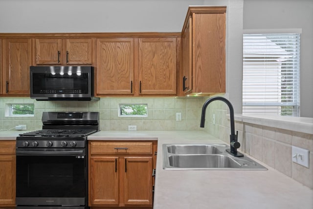 2009 Campfield Pkwy, Austin, TX 78745 - kitchen featuring appliances with stainless steel finishes, a sink, backsplash, and light countertops