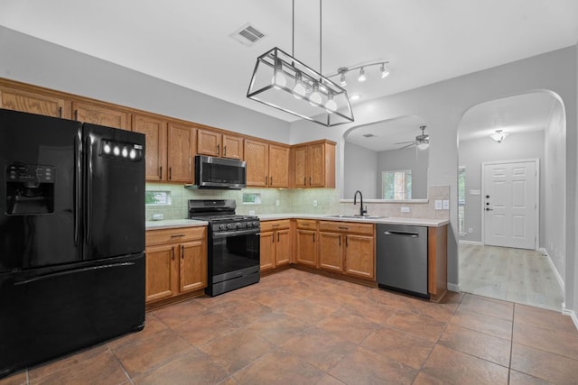 2009 Campfield Pkwy, Austin, TX 78745 - kitchen featuring black fridge, dishwashing machine, range with gas stovetop, stainless steel microwave, and a sink