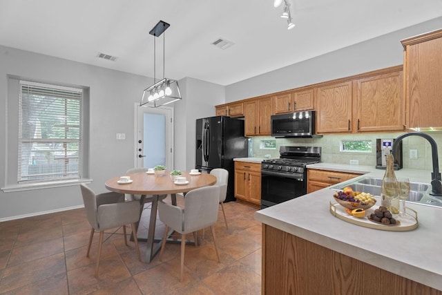 2009 Campfield Pkwy, Austin, TX 78745 - kitchen with stainless steel appliances, a sink, light countertops, backsplash, and pendant lighting