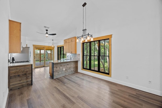 16202 Kicking Bird Dr, Leander, TX 78641 - kitchen with wood finished floors, baseboards, light countertops, ceiling fan, and high vaulted ceiling