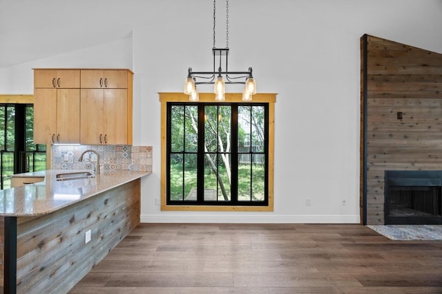 16202 Kicking Bird Dr, Leander, TX 78641 - kitchen with a sink, plenty of natural light, light brown cabinets, light stone counters, and lofted ceiling