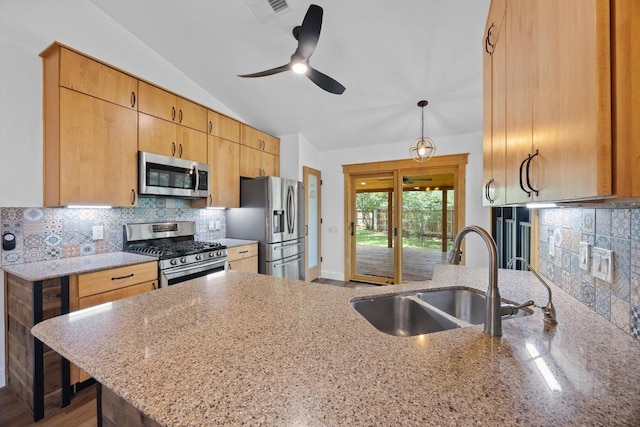 16202 Kicking Bird Dr, Leander, TX 78641 - kitchen featuring appliances with stainless steel finishes, a sink, light stone counters, a ceiling fan, and lofted ceiling