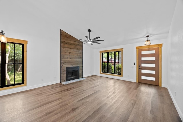 16202 Kicking Bird Dr, Leander, TX 78641 - unfurnished living room with ceiling fan, wood finished floors, healthy amount of natural light, a large fireplace, and high vaulted ceiling