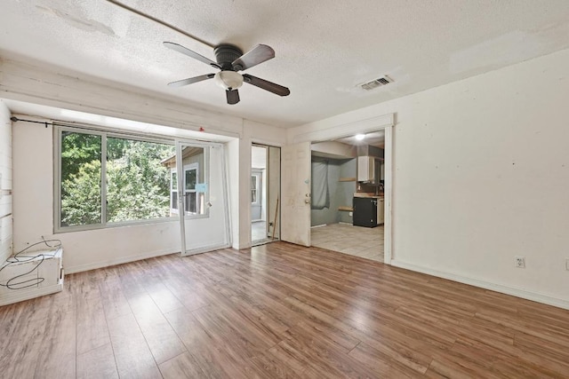 6212 Boxcar Run, Austin, TX 78745 - unfurnished living room featuring a ceiling fan, wood finished floors, a textured ceiling, and baseboards