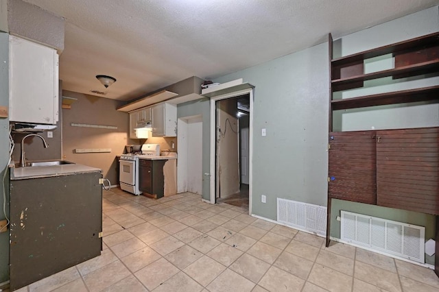 6212 Boxcar Run, Austin, TX 78745 - kitchen with white gas range oven, a sink, light countertops, under cabinet range hood, and light tile patterned floors