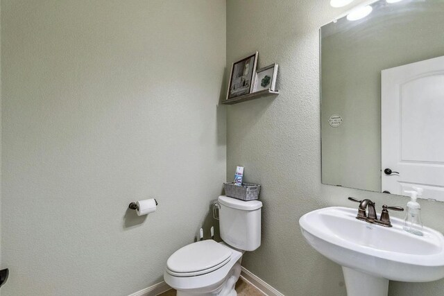 1084 Violet Ln, Kyle, TX 78640 - bathroom with toilet, a sink, and baseboards