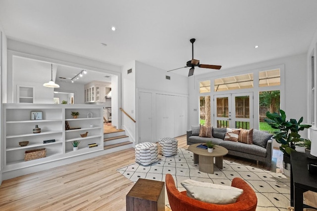 4517 Ave G, Austin, TX 78751 - living area with light wood-style flooring, ceiling fan, stairs, and french doors