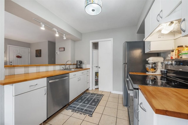5616 Emerald Forest Dr Unit 111, Austin, TX 78745 - kitchen featuring appliances with stainless steel finishes, wood counters, white cabinetry, a sink, and rail lighting