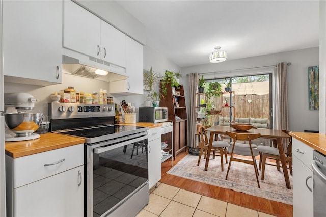 5616 Emerald Forest Dr Unit 111, Austin, TX 78745 - kitchen featuring appliances with stainless steel finishes, under cabinet range hood, butcher block countertops, and white cabinets