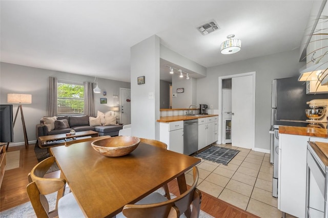 5616 Emerald Forest Dr Unit 111, Austin, TX 78745 - dining room featuring track lighting, baseboards, and light tile patterned floors