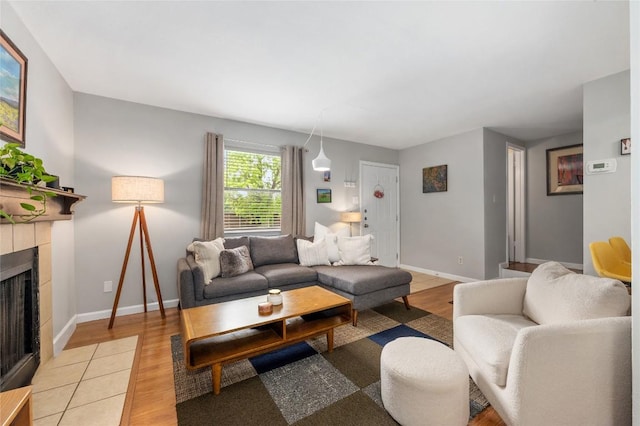 5616 Emerald Forest Dr Unit 111, Austin, TX 78745 - living room featuring light wood finished floors, a fireplace, and baseboards