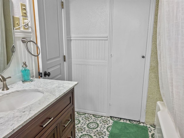 206 S Clear St, San Saba, TX 76877 - full bath featuring vanity, wainscoting, and a decorative wall