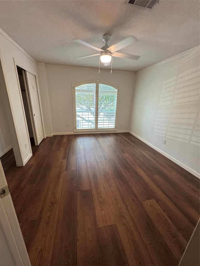 4424 Campo Verde Dr, Austin, TX 78749 - spare room featuring ornamental molding, a textured ceiling, a ceiling fan, dark wood-style floors, and baseboards