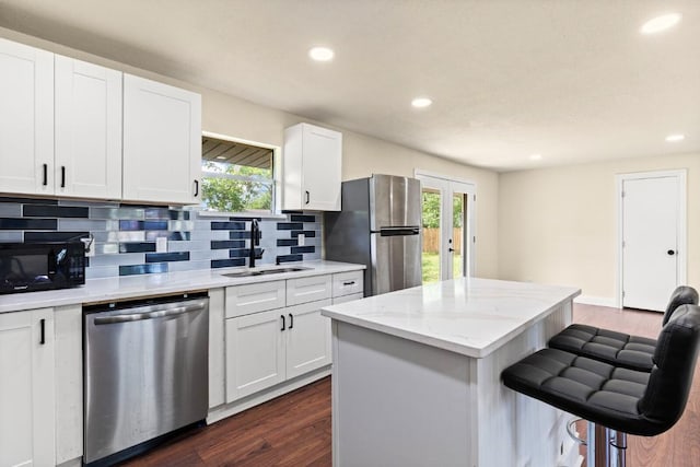 1145 E Sunset St, Waco, TX 76704 - kitchen with stainless steel appliances, a sink, a breakfast bar, recessed lighting, and dark wood finished floors