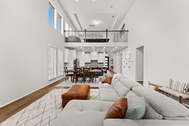 170 Fawn River Run, Kyle, TX 78640 - living area with a high ceiling, wood finished floors, and baseboards
