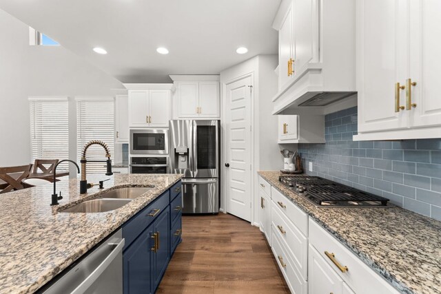 170 Fawn River Run, Kyle, TX 78640 - kitchen with stainless steel appliances, a sink, blue cabinets, white cabinetry, and recessed lighting
