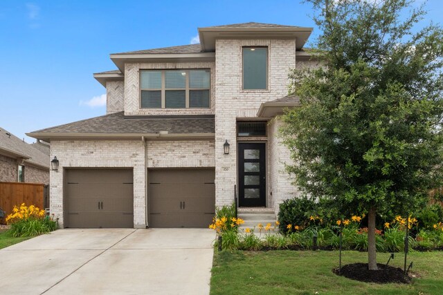 170 Fawn River Run, Kyle, TX 78640 - view of front facade featuring driveway, a garage, roof with shingles, and brick siding