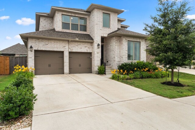 170 Fawn River Run, Kyle, TX 78640 - prairie-style home featuring a garage, concrete driveway, brick siding, and a shingled roof