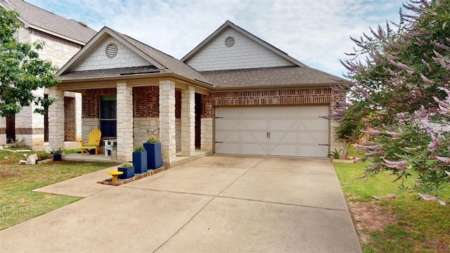 11405 Kirkland Hill Path, Austin, TX 78754 - view of front facade with stone siding, roof with shingles, an attached garage, driveway, and brick siding