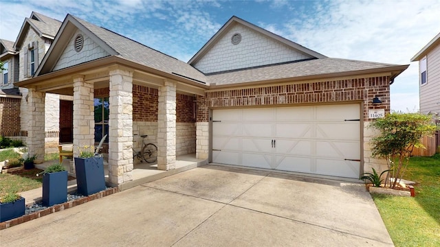 11405 Kirkland Hill Path, Austin, TX 78754 - view of front of house with driveway, roof with shingles, a garage, stone siding, and brick siding