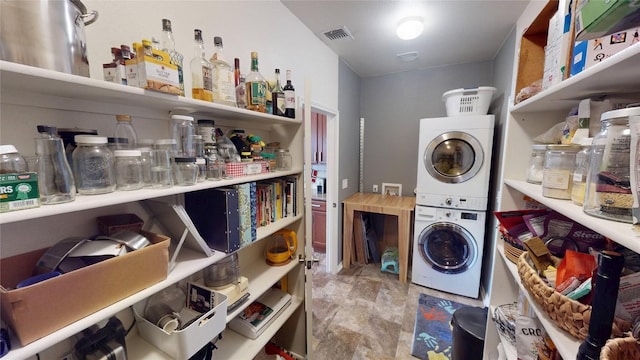 11405 Kirkland Hill Path, Austin, TX 78754 - laundry area with stacked washer / drying machine and stone finish flooring