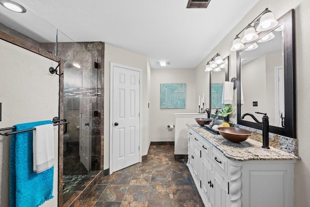 106 Guadalupe Dr, Hutto, TX 78634 - bathroom featuring double vanity, stone finish flooring, a stall shower, and baseboards