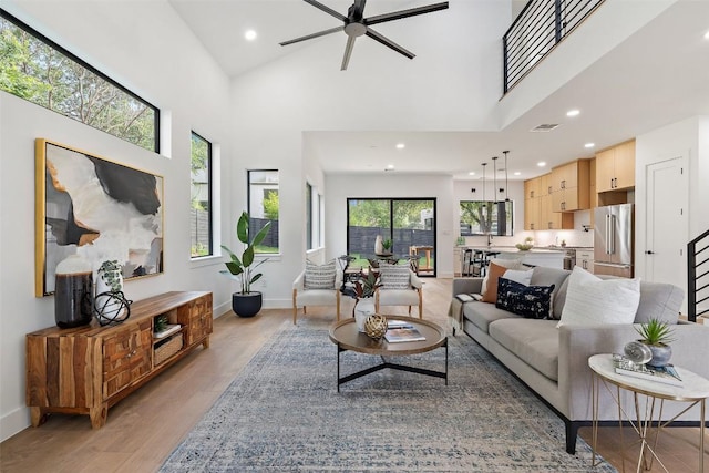 2303 Westworth Cir, Austin, TX 78704 - living area with ceiling fan, light wood finished floors, recessed lighting, baseboards, and a towering ceiling