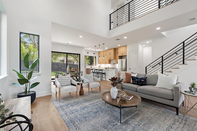 2303 Westworth Cir, Austin, TX 78704 - living area with light wood-style floors, a towering ceiling, stairway, recessed lighting, and baseboards