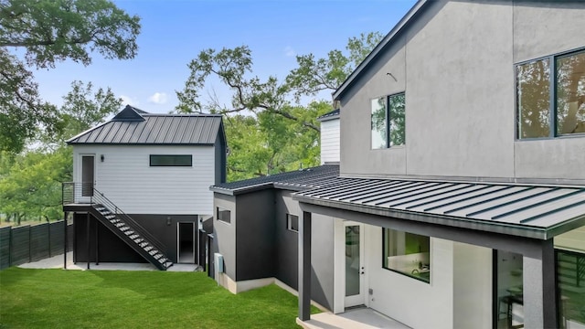 2303 Westworth Cir, Austin, TX 78704 - rear view of house featuring a standing seam roof, metal roof, stairs, and stucco siding