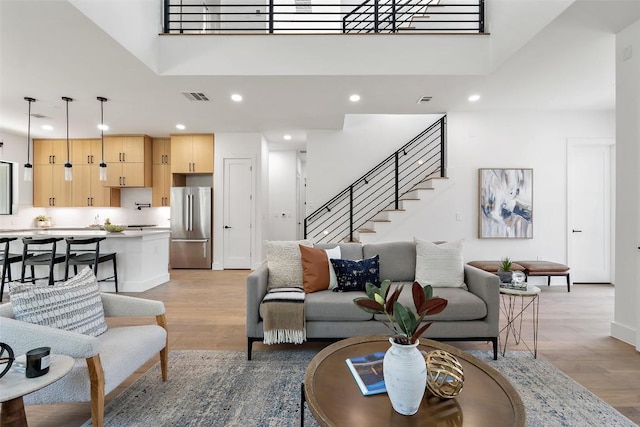 2303 Westworth Cir, Austin, TX 78704 - living room featuring light wood-type flooring, recessed lighting, stairway, baseboards, and a high ceiling